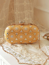White oval clutch bag by The Tan Clan with sleek design and compact size, ideal for elegant occasions.