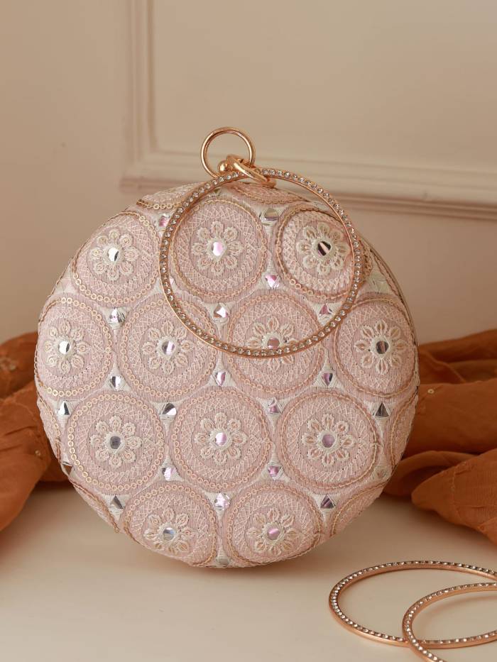 White Inaara round clutch bag by The Tan Clan, featuring a sleek, minimalist design with a smooth surface and compact size.