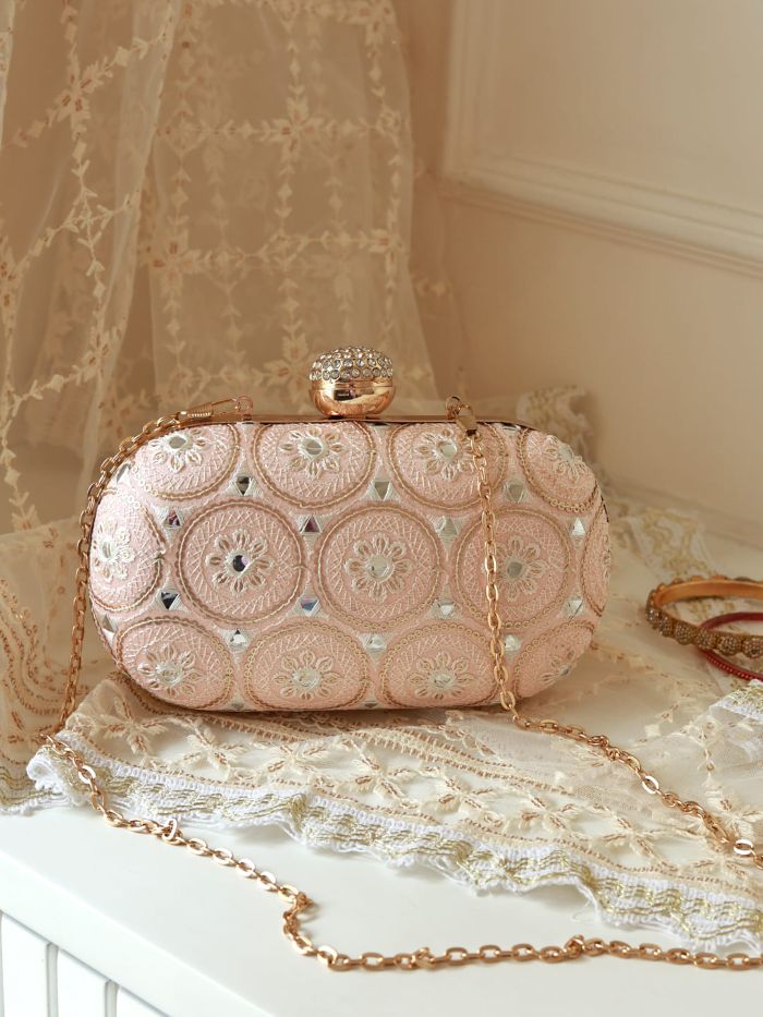 Yellow oval clutch bag by The Tan Clan with white accents, featuring a sleek design and compact size for elegant occasions.