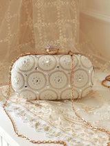 Yellow oval clutch bag by The Tan Clan with white accents, featuring a sleek design and compact size for elegant occasions.